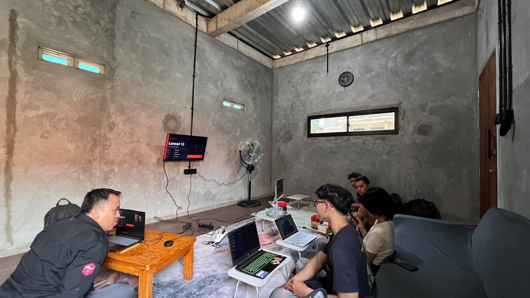 Mentor memandu materi Laravel 12 di depan layar